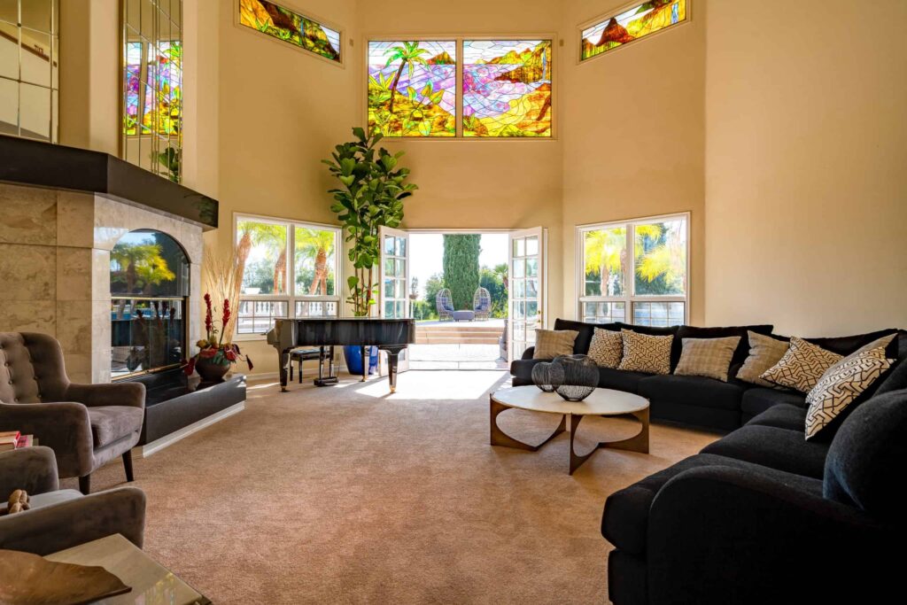 The great room at Villa Oasis, with a fireplace, piano and seating overlooking the grounds