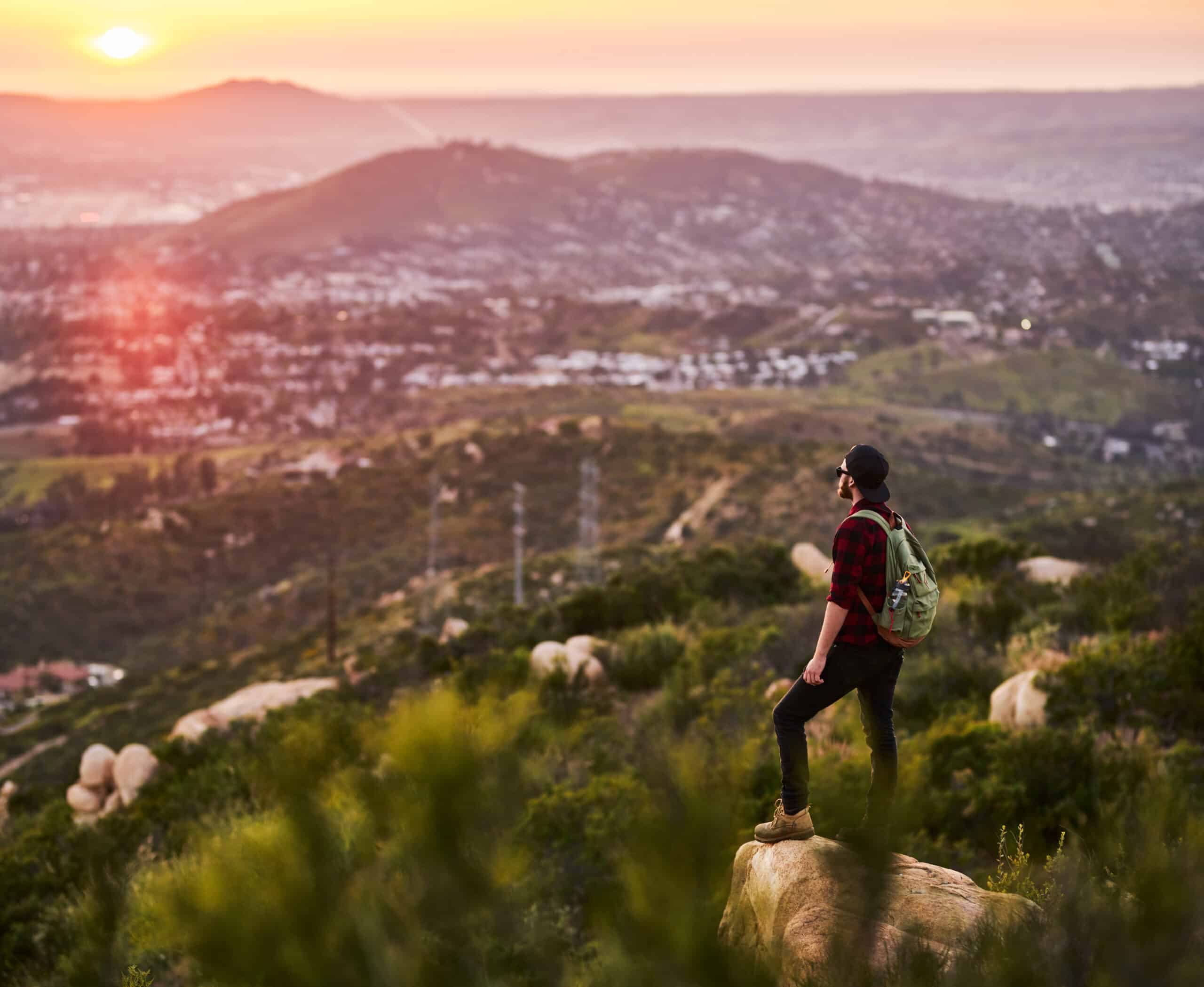 young man hiking enjoying sunset close to san diego california