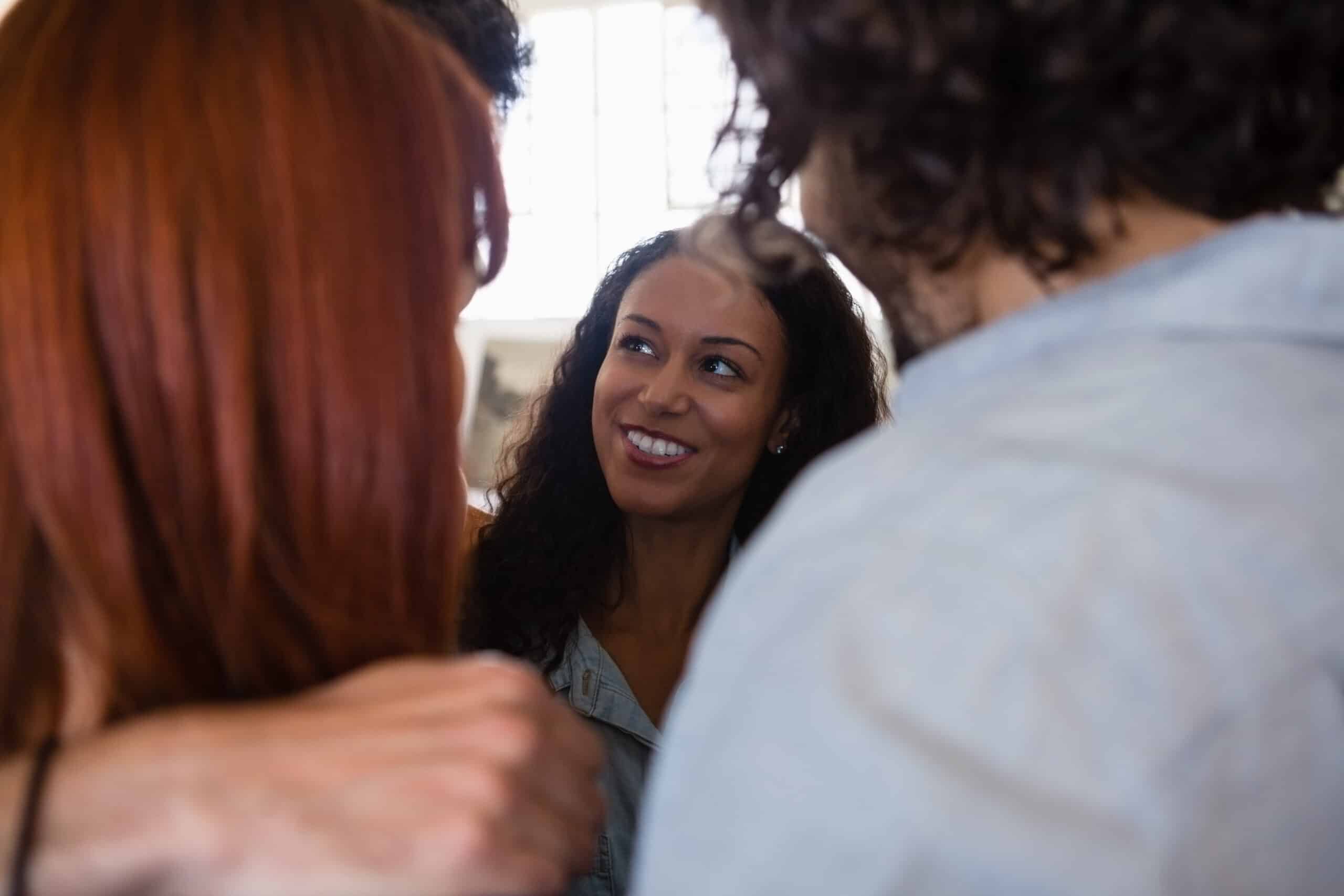 Close up of smiling friends huddling while standing in art class