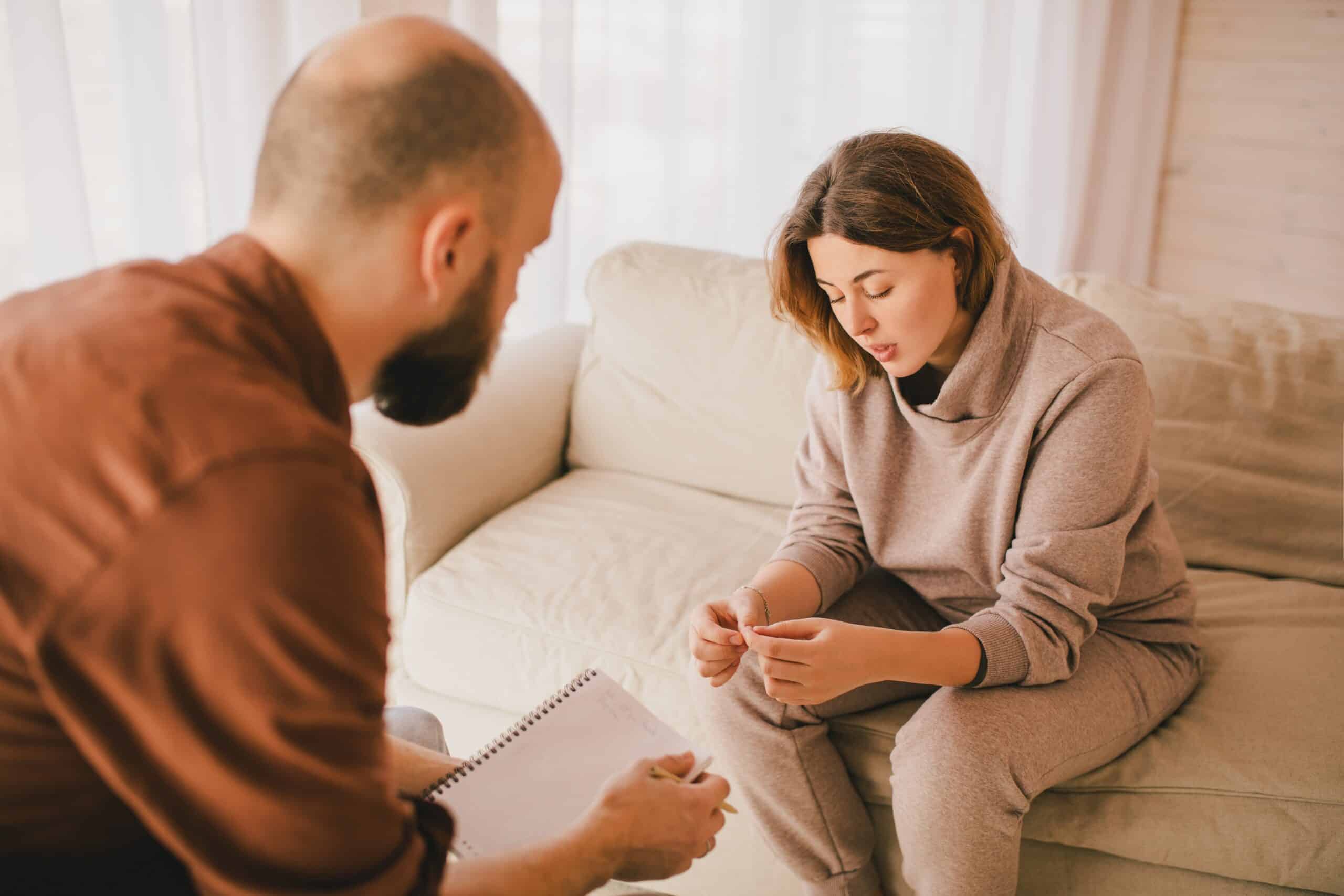 Young woman patient having consultation with psychotherapist in his office. Medical mental help and support.