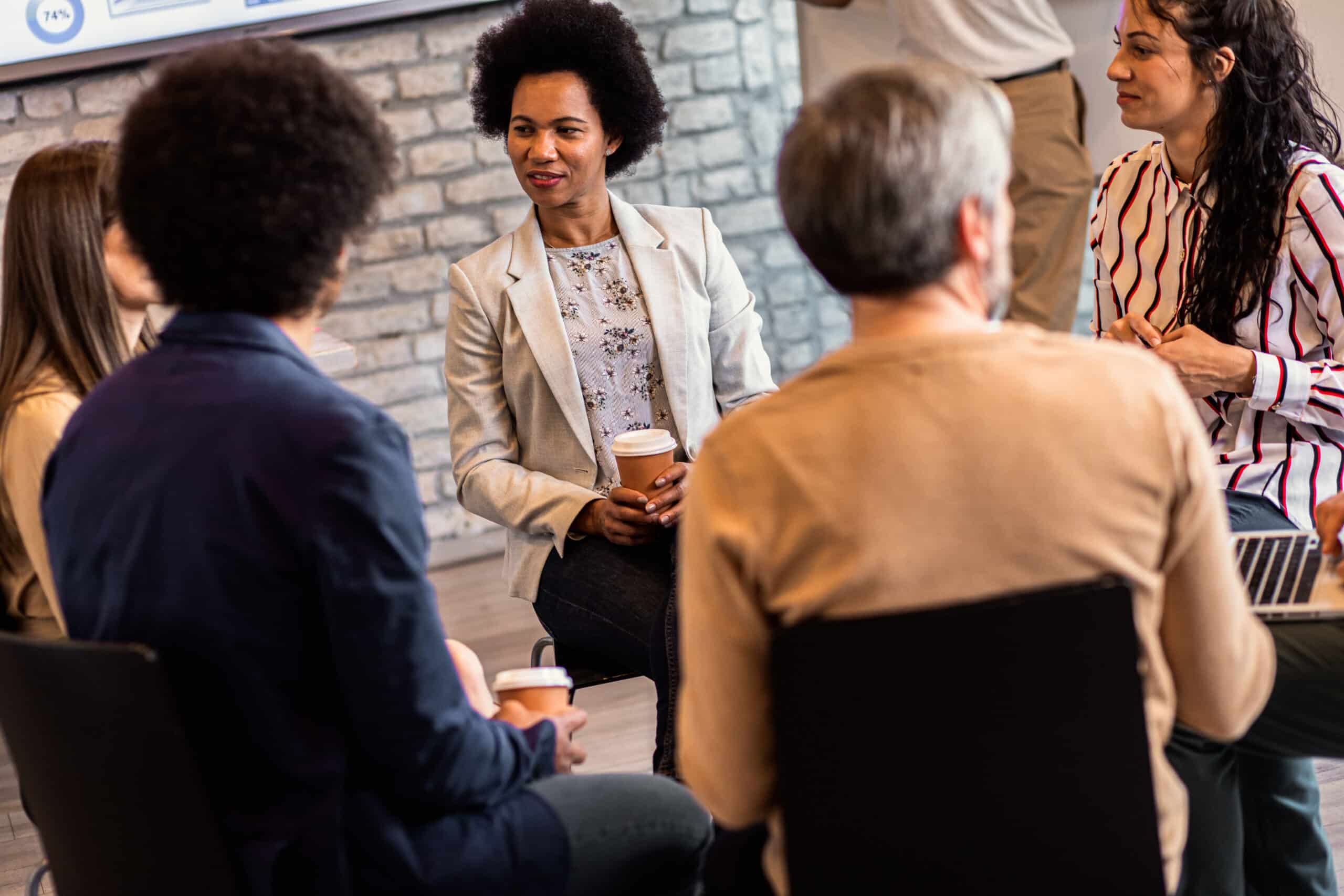 Group of diverse group of business people having a meeting while sitting in circle.