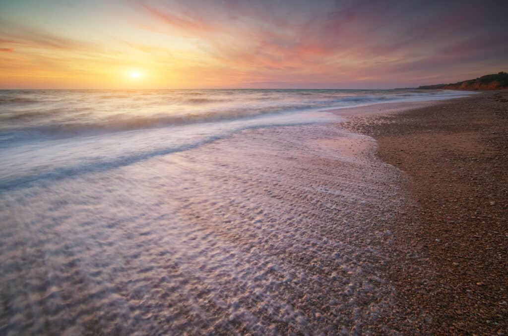 beach at sunset with water going back