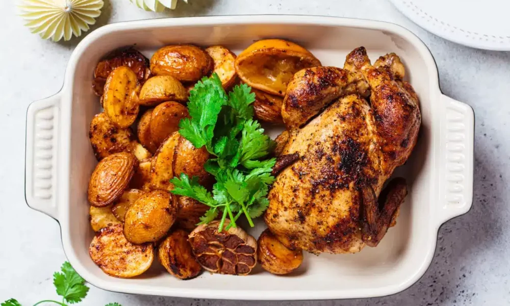Roasted whole chicken with potatoes in a tray