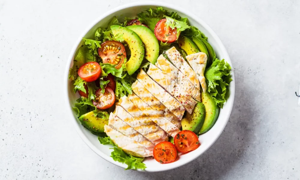 Grilled chicken breast salad with avocado and cherry tomatoes